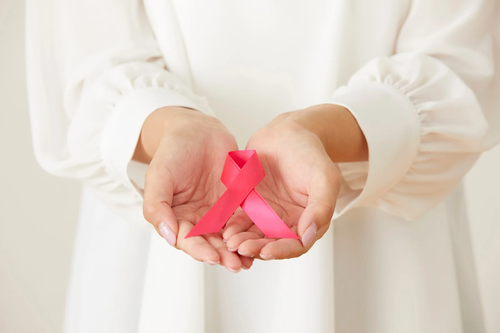 Žena drži ružičastu vrpcu za podizanje svijesti o raku dojke